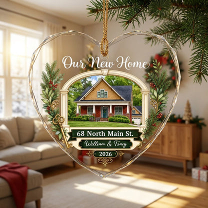 Heart glass ornament with archway, brick and yellow house, pine branches, gold key, and 'Our New Home' text.