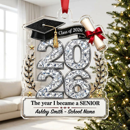 Custom-cut clear acrylic ornament shaped like a graduation cap with Class of 2026, diploma, laurels, and name plaque.