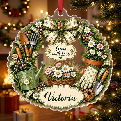 Scalloped acrylic ornament with a floral gardening wreath, tools, and "Grow with Love" plus a personalized name.
