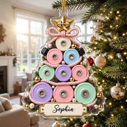 Acrylic Christmas tree ornament of stacked pastel weight plates with a gold star dumbbell and a cream name banner.