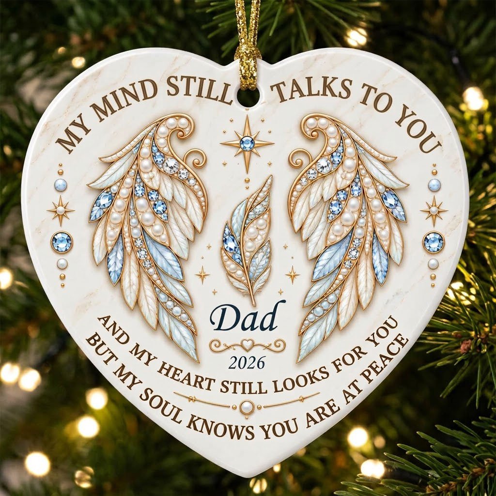 White heart ceramic ornament with jeweled angel wings, blue gems, gold scrollwork, personalized name and year.