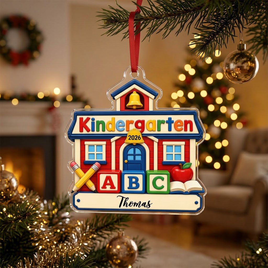Red schoolhouse acrylic ornament with Kindergarten 2026, ABC blocks, pencils, apple, and a name on a white banner.
