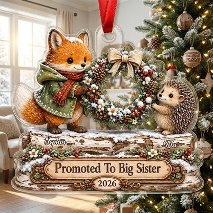 Acrylic ornament with a fox and hedgehog holding a wreath above a wood-style name banner with snowy accents.