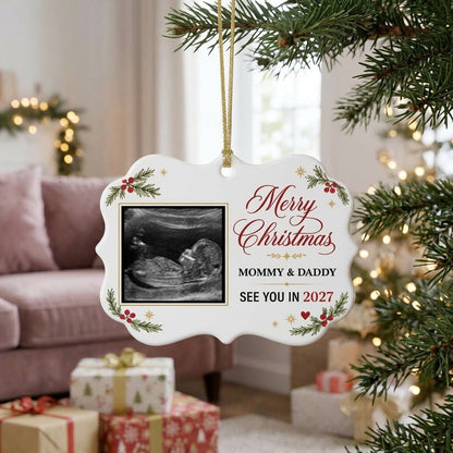 Round ceramic ornament with ultrasound photo, pine branches with red berries, gold starbursts and a red heart icon.