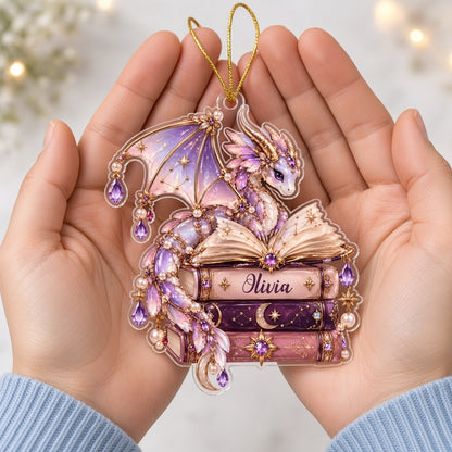 Pastel purple and gold dragon on an open book atop stacked books with jewels and pearls on a clear acrylic ornament.