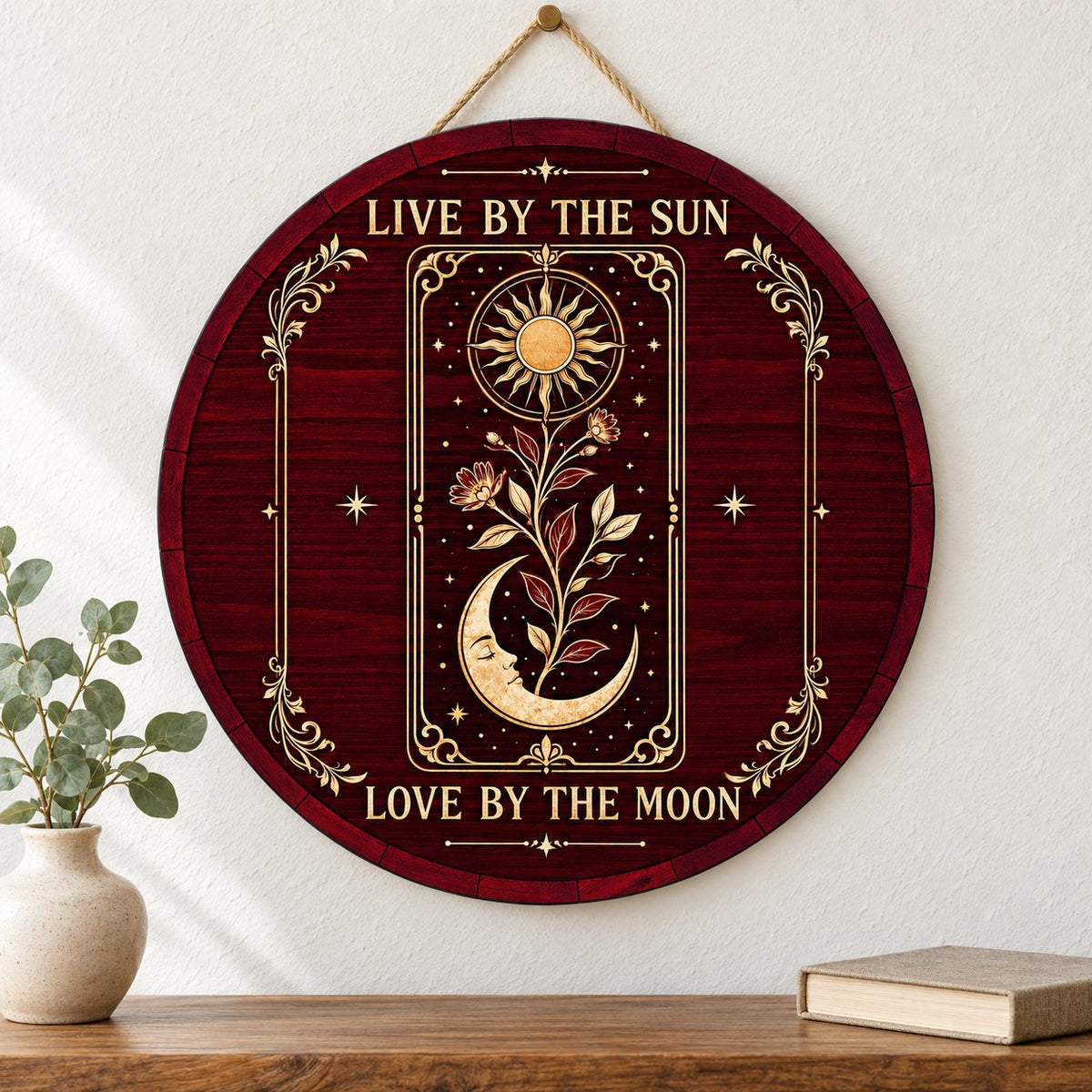 Round wooden sign with tarot-style sun and sleeping moon, floral vine, stars, and the words Live by the Sun, Love by the