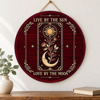 Round wooden sign with tarot-style sun and sleeping moon, floral vine, stars, and the words Live by the Sun, Love by the