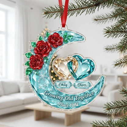 Custom-cut acrylic ornament of a faceted crescent moon with red roses, snowflakes, and two intertwined crystal hearts.