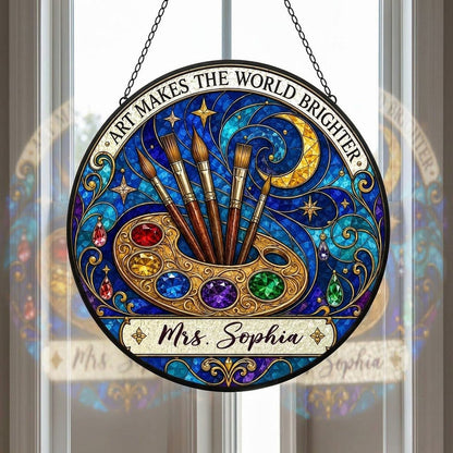 Round stained-glass suncatcher with golden palette, five brushes, moon, and 'Art Makes the World Brighter'.