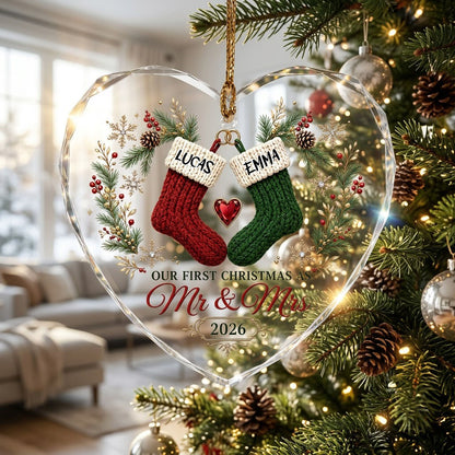 Heart-shaped glass ornament with red and green stockings hanging from gold rings and a red gemstone heart