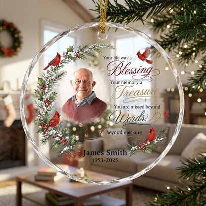 Round glass ornament with memorial quote, four red cardinals, pine and holly greenery, and a center photo portrait.