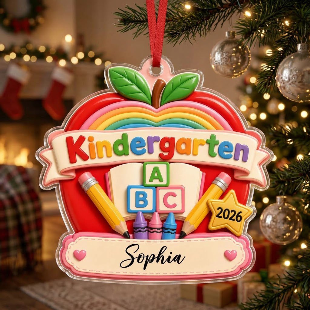 Red apple acrylic ornament with 'Kindergarten 2026', rainbow, ABC blocks, crayons, pencils, star badge, and a name banne