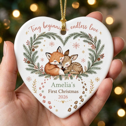 Heart ceramic ornament with sleeping baby fox and fawn in an evergreen wreath with berries and snowflakes.