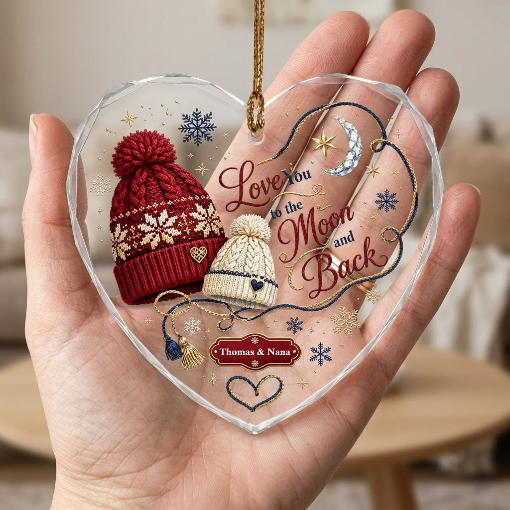 Heart glass ornament with red and cream pom-pom beanies, silver moon, gold star, and Love You Moon and Back text.