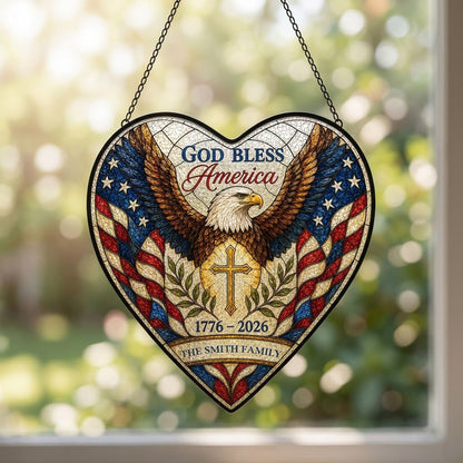 Heart-shaped stained glass suncatcher with a bald eagle over a golden cross and American flag border.