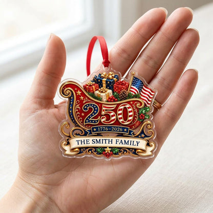 Acrylic ornament shaped like a Santa sleigh with '250', '1776-2026', US flag and a family name banner.