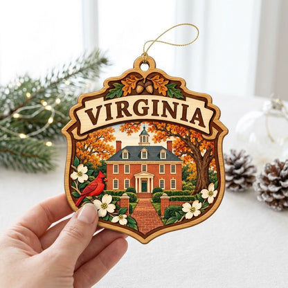 Shield-shaped wood ornament with “VIRGINIA,” colonial brick building, cardinal, acorns and white dogwood flowers.