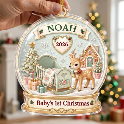 Acrylic snowglobe ornament with Baby's 1st Christmas, fawn with red bow, cradle, tree, gifts and gingerbread house