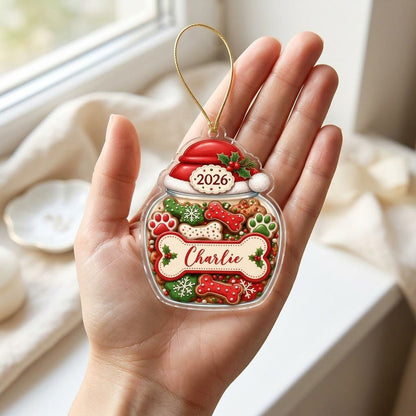 Custom-cut acrylic ornament shaped like a cookie jar with Santa hat, dog bone name plaque, and 2026 year badge.
