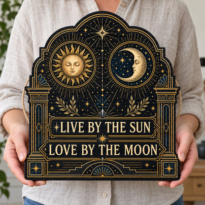 Arched wooden sign with sun and moon faces, constellations, and 'Live By The Sun, Love By The Moon'.