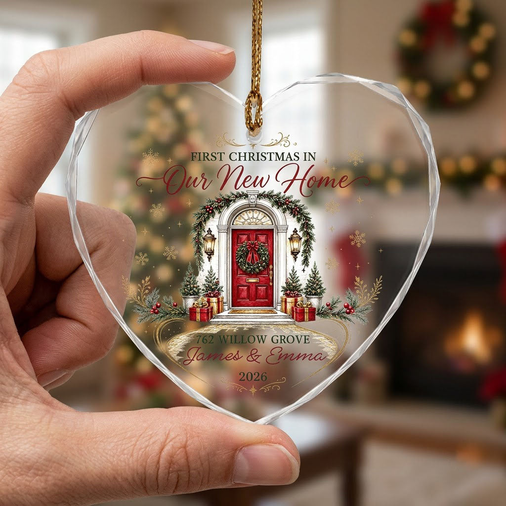 Heart-shaped glass ornament with a red front door, wreath, garland, lanterns, gift boxes, and gold snowflakes.