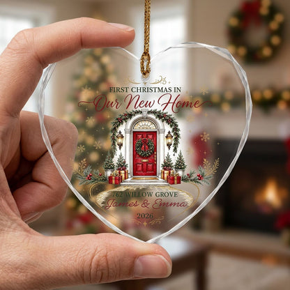 Heart-shaped glass ornament with a red front door, wreath, garland, lanterns, gift boxes, and gold snowflakes.