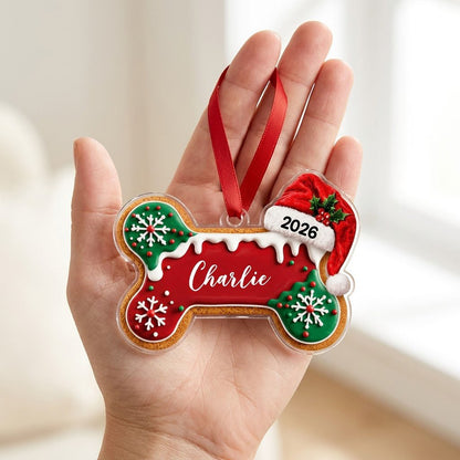 Acrylic ornament shaped like a gingerbread dog bone with Santa hat, white icing, snowflakes, and red-green sprinkles.