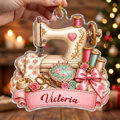 Custom-cut acrylic ornament with vintage cream sewing machine, pink banner, roses, thread spools and scissors.