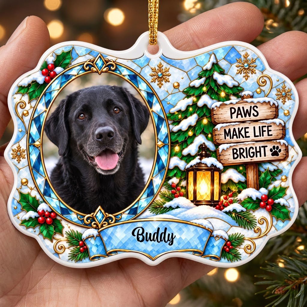 Scalloped ceramic medallion ornament with dog photo, blue stained glass frame, lantern, and Christmas tree in snow.