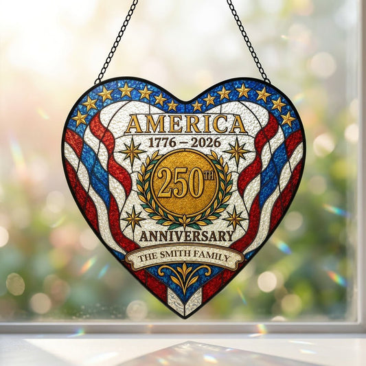 Heart suncatcher with red, white and blue stripes, gold medallion, laurel wreath, and 'America 1776–2026' text.