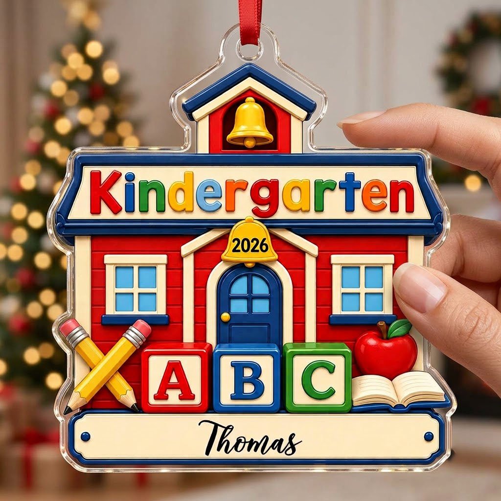 Red schoolhouse acrylic ornament with Kindergarten 2026, ABC blocks, pencils, apple, and a name on a white banner.