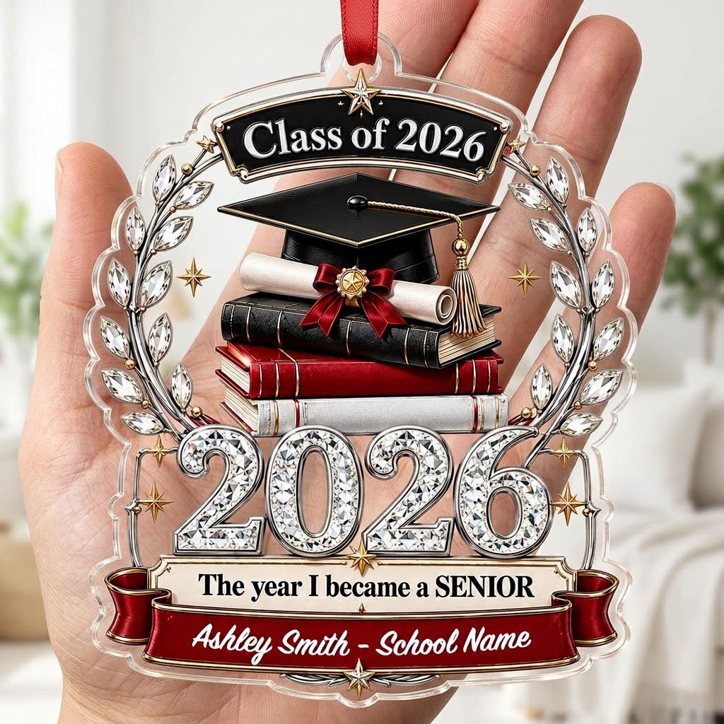 Acrylic ornament shows Class of 2026 text, cap, diploma, jeweled laurel wreath and banners personalized with name and sc