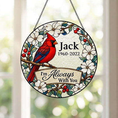 Round stained glass–style suncatcher with a red cardinal on a branch, white flowers, red berries, and a scroll banner.