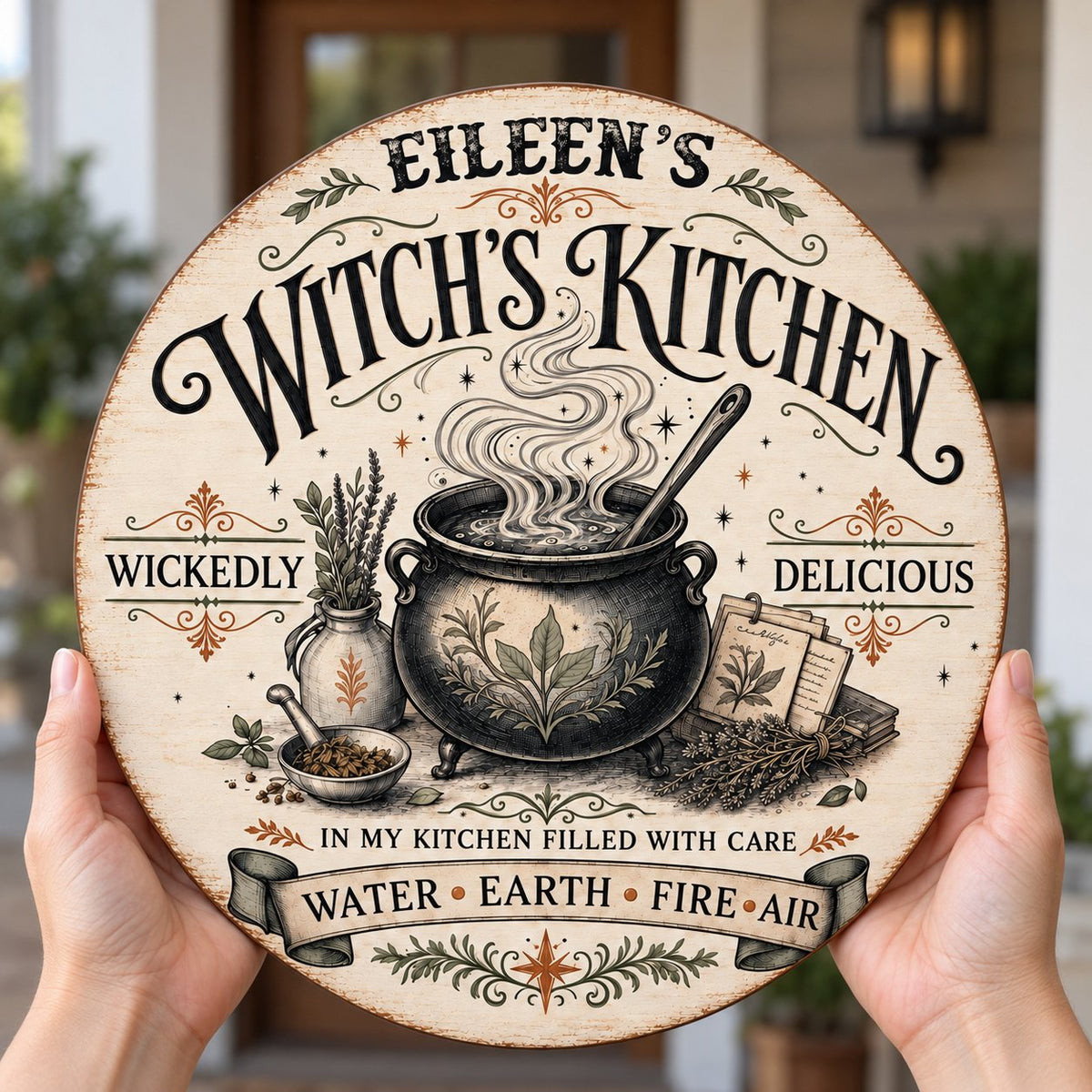 Round wooden hanging sign with a bubbling cauldron, herbs, spellbook, stars and the words Witch's Kitchen.