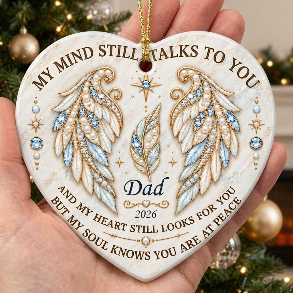 White heart ceramic ornament with jeweled angel wings, blue gems, gold scrollwork, personalized name and year.
