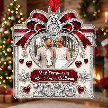 Acrylic ornament with red glitter bow, engagement ring, heart photo frame, snowflakes, and Mr. & Mrs. name and year.