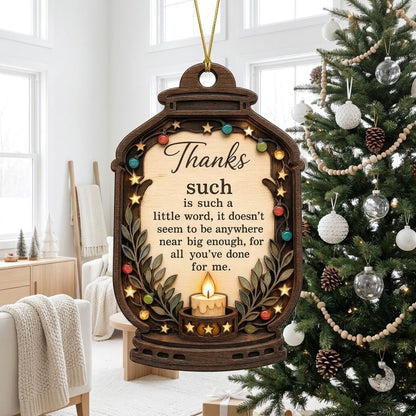 Lantern-shaped wood ornament with candle, colorful fairy lights, leafy branches, and a thank-you quote.