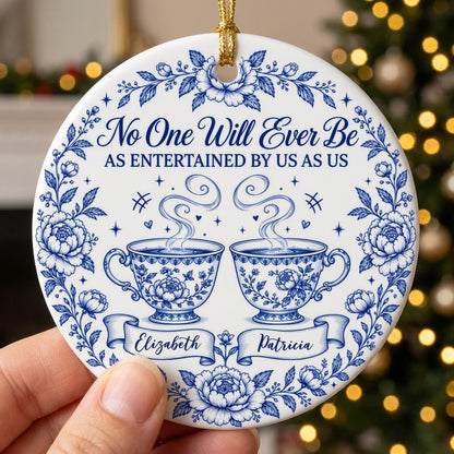 Round white ceramic ornament with blue floral border and two teacups, personalized with two names