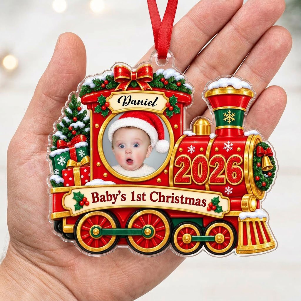 Red and gold train ornament with circular baby photo, bow, holly, wreath and 'Baby's 1st Christmas' on a scroll banner.