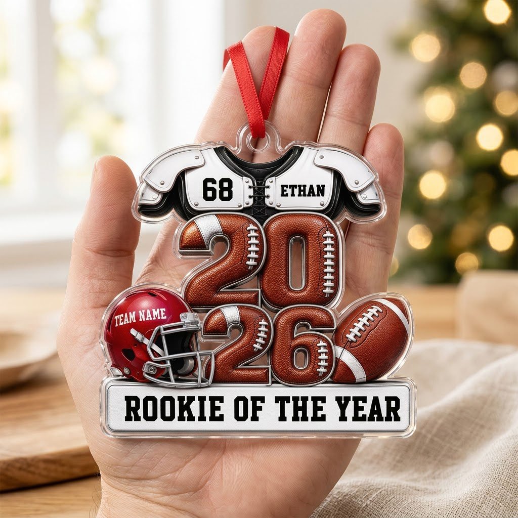 Acrylic ornament shaped like football gear with 2026 numbers, red helmet, ball and 'Rookie of the Year' nameplate.