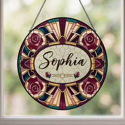 Round stained glass-style suncatcher with red and pink roses, a cream oval name panel, and black leaded lines.