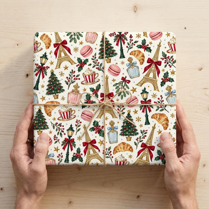 Cream paper with gold Eiffel Towers, Christmas trees, street lamps, macarons, croissants, holly and stars pattern.