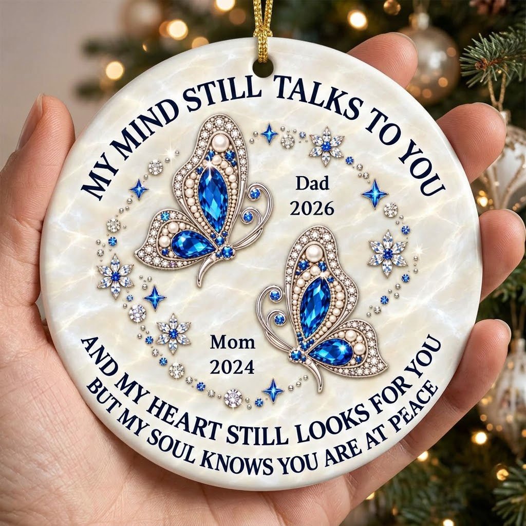 Round ceramic ornament with jeweled blue butterflies, floral rhinestones, and a cream marble background with memorial qu