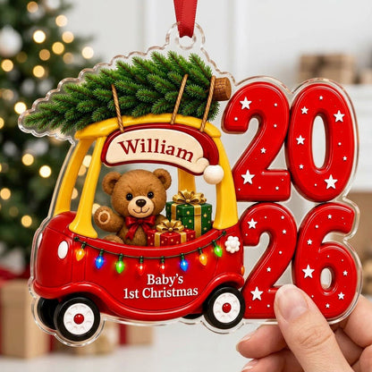 Red toy car with pine tree, teddy bear and gifts, "Baby's 1st Christmas" and 2026 star-pattern numbers on clear acrylic.