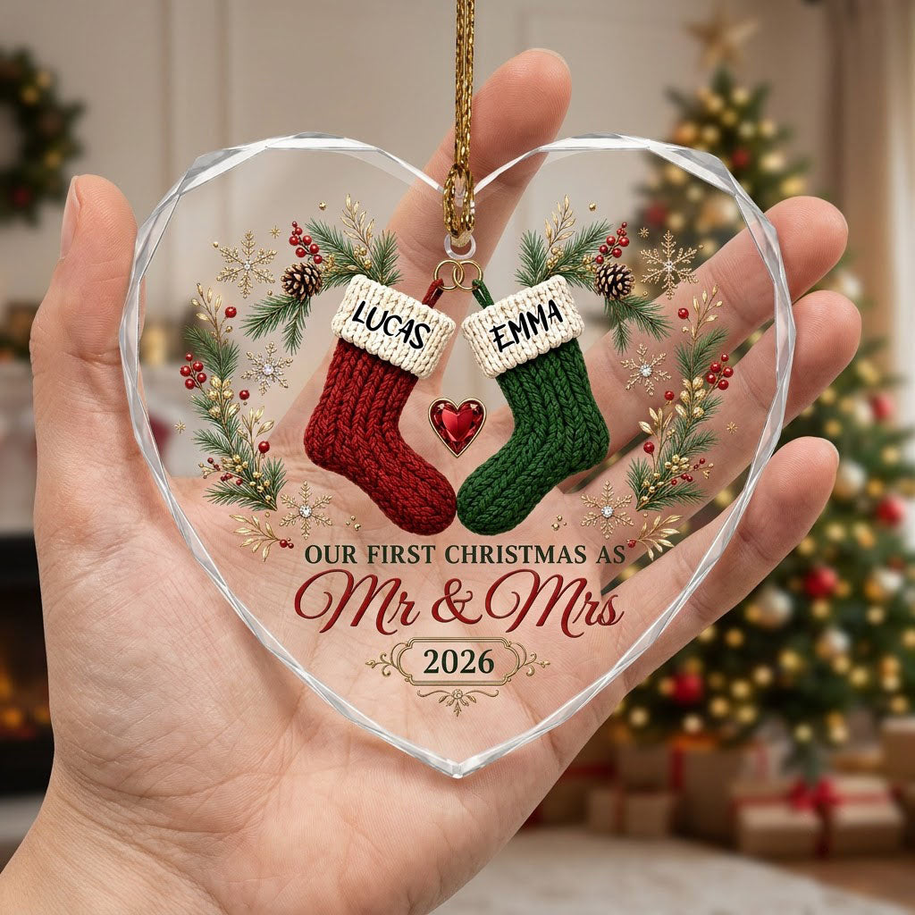 Heart-shaped glass ornament with red and green stockings hanging from gold rings and a red gemstone heart
