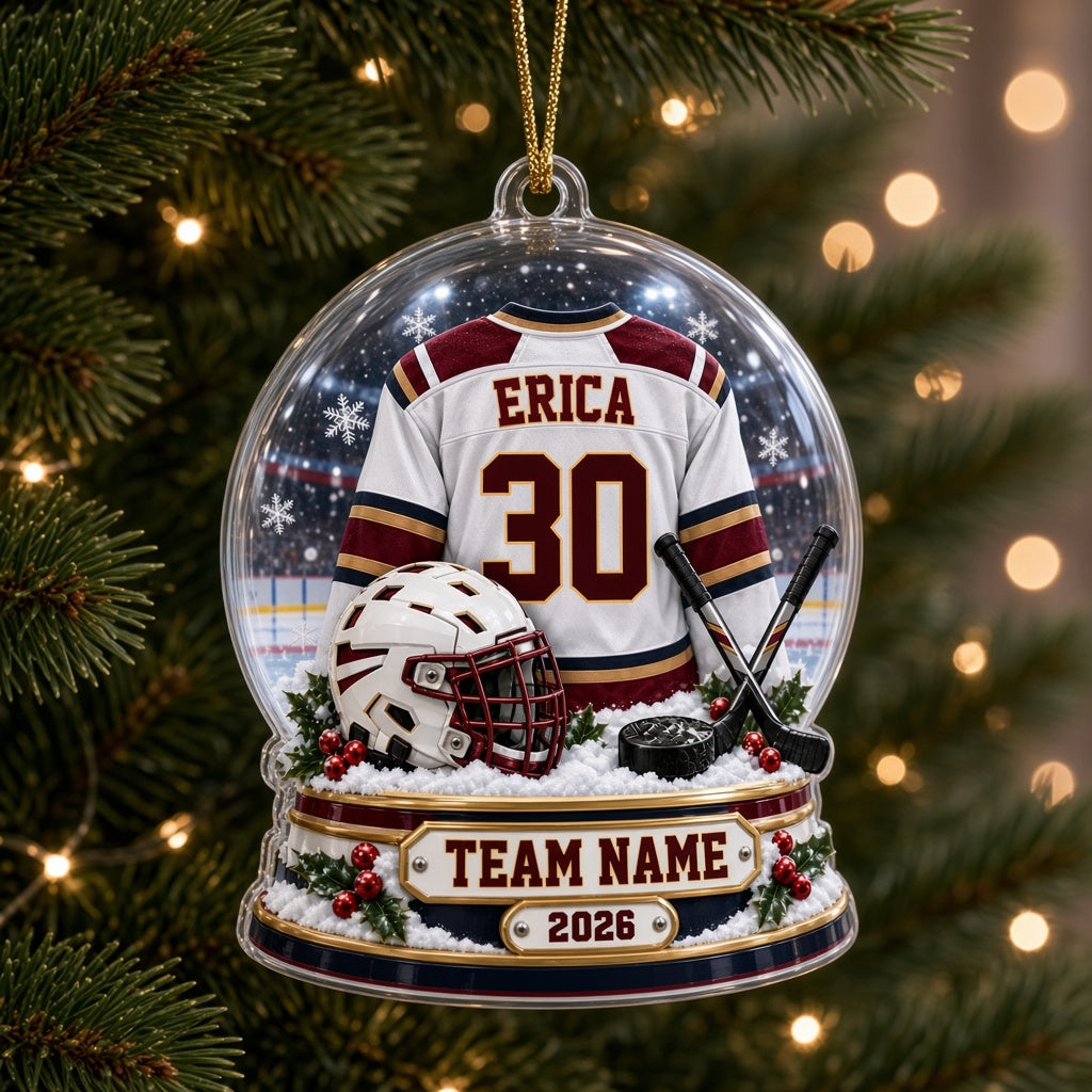 Acrylic snow globe ornament with hockey jersey, helmet, crossed sticks, puck, snowflakes and holly accents.