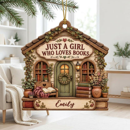 House-shaped wood ornament with 'JUST A GIRL WHO LOVES BOOKS', bookshelves, green door with wreath, and the name Emily.
