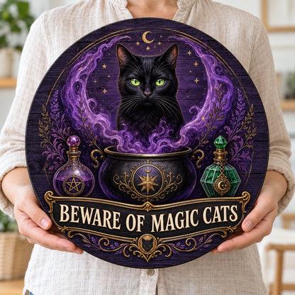 Round wooden sign with a black cat in purple smoke rising from a cauldron and the text BEWARE OF MAGIC CATS.