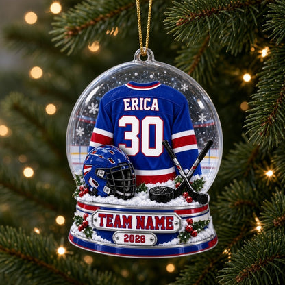 A custom-cut snow globe acrylic ornament with hockey jersey, helmet, crossed sticks, puck, and holly on the base.