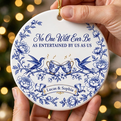 Round ceramic ornament with blue toile border, two birds, clinking floral teacups and gold music notes with two names.
